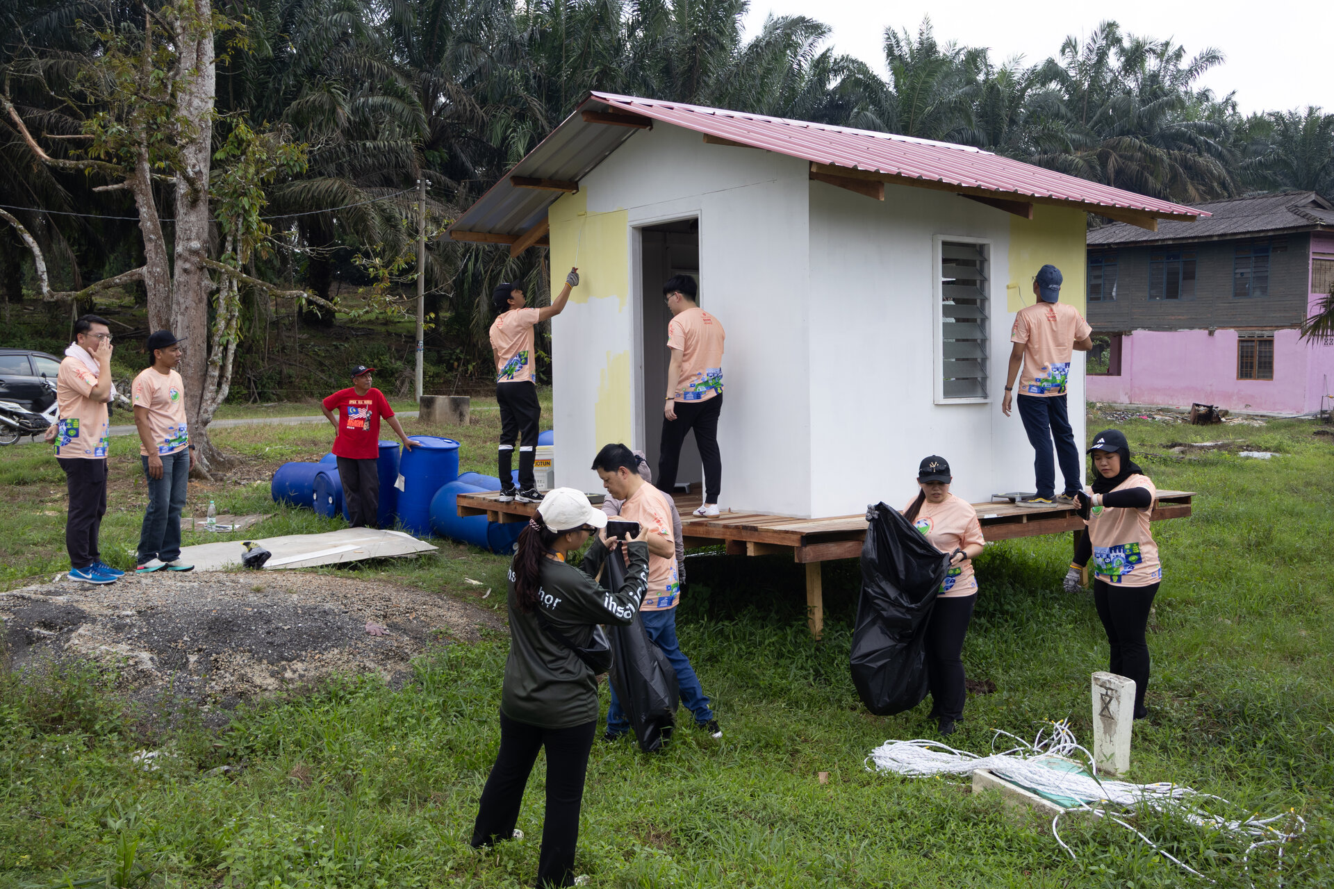 Staff volunteers painting and beautifying a Floating House in Kota Tinggi, Johor as part of community restoration efforts.